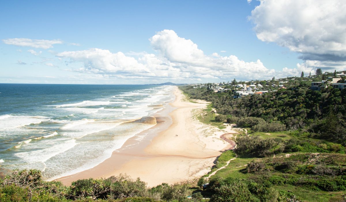Sillhouette of Two people Walking Trouht a Beach of Noosa Heads on Sunshine Coast, Australia